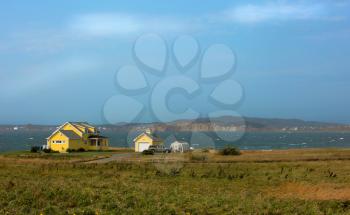 Beautiful yellow house by the sea.  Rugged cost line of Havre Aubert in magdalen island in Quebec, Canada