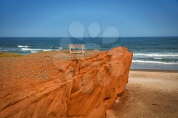 Red cliff in Havre aux maisons with waves in the ocean in the St-Lawrence golfe