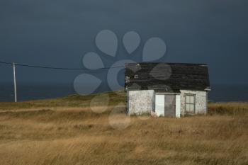 Old fisherman house with tiles in a dark grey sky in Magdalen island Quebec in Canada