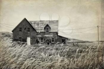 Derelict house in a middle of a field in sepia with texture to look like an used picture