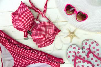 Ready to go on the beach with a red bikini, sandals, hat and heart shape sunglasses