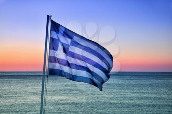 Greek flag with sunset in background
