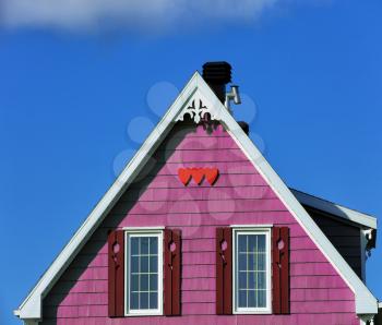 Detail of a beige rooftop with three red wooden hearts shape in Iles de la Madeleine in Canada