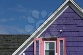 Detail of a purple rooftop with pink windows against a blue sky in Iles de la Madeleine in Canada