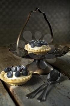 Blueberry tarts with spoons in a stand with a rustic style