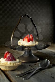 Strawberry tarts with spoons in a stand with a rustic style