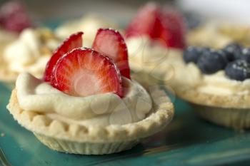 Berries tarts in a green tray 
