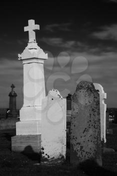 Different graves in a cemetery in black and white.