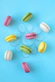 Top view of colorful french traditional macarons on blue background