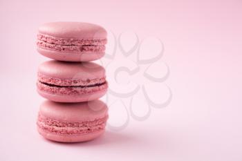 Stack of french tradional pink macarons on pink background