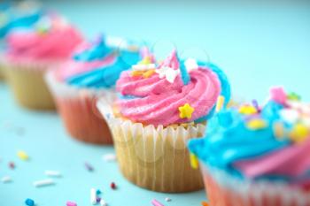 Cupcakes with blue and pink icing on a blue background