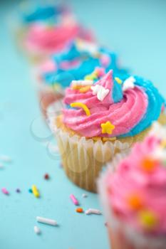 Cupcakes with blue and pink icing on a blue background