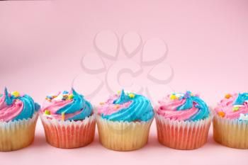 Cupcakes with blue and pink icing on a pink background