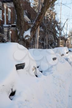 Car covered of snow and parked in a street during a snowstorm in Montreal in  Canada
