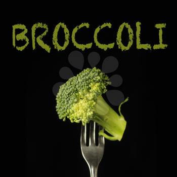 Broccoli on a fork on a black background