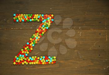 Letter Z from alphabet made with star shape candy on a wooden background