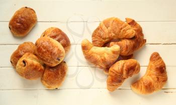 Croissant and pain au chocolat, french pastries on white wooden background