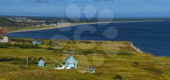 Beautiful blue house by the sea.  Rugged cost line of Havre Aubert in magdalen island in Quebec, Canada