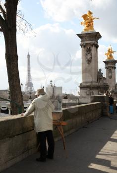PARIS, FRANCE - MARCH 04, 2014:  Old man artist drawing the eiffel tower along the la seine river in Paris, France.  